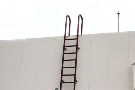  Old vertical industrial metal rusted ladder. Staircase to Water