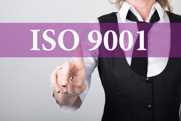 ISO 9001 written on virtual screen. technology, internet and networking concept. woman in a black business shirt presses button on virtual screens