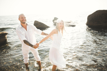 happy just married young wedding couple celebrating and have fun at beautiful beach sunset