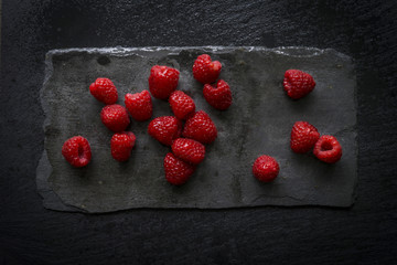 Raspberries on black slate board