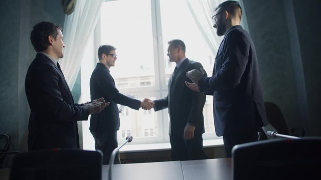 Business partners greeting each other after signing contract