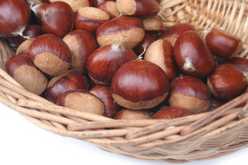 castagne in un cesto su sfondo bianco