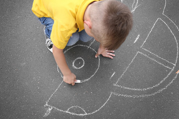 Boy with chalk drawing car