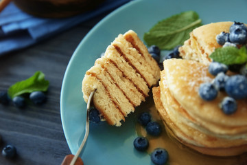 Delicious pancakes with blueberries and honey, closeup