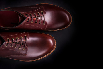 Brown oxford shoes on black background. Top view. Copy space.