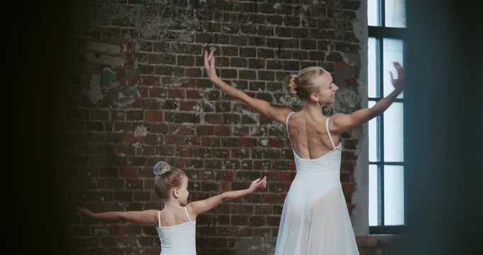 adult ballerina coached a little girl daughter to dance class
