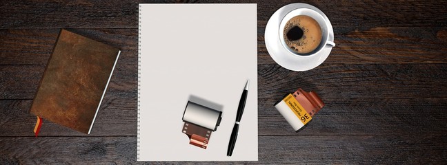 Business table with 35mm camera photo film canisters, coffe,  notebook and white notepad 