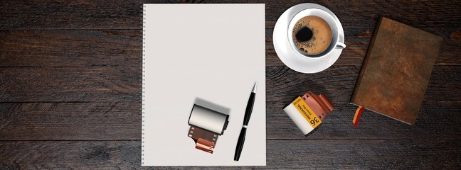 
Business table with 35mm camera photo film canisters, coffe,  notebook and white notepad 