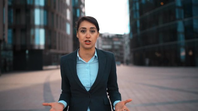 POV. Portrait of young attractive sexy caucasian businesswoman Swear and cuss on You. Pomade, brownhair, lady. Negation concept. Blackguard abuse. Formal suit. Modern glass buildings bg. Sunrise. Teal