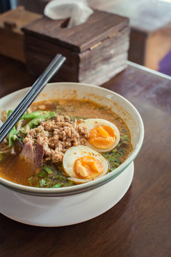 Noodle Tom Yam, hot spicy soup served with boiled egg.