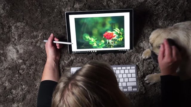 Frau liegt auf dem Boden und benutzt ein Tablett Computer