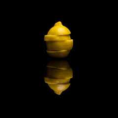 One sliced isolated yellow lemon on black reflective background