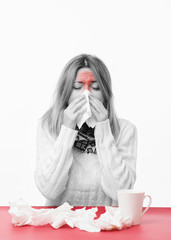 Young slim woman is sneezing. Grey and red colors.