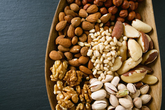 different knds of nuts in a wooden plate