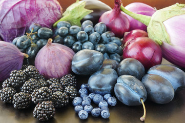 Blue and purple food. Berries, fruits and vegetables on a black background.