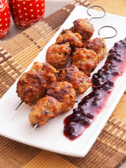 Lamb meatballs baked on skewers with cranberry sauce