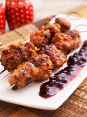 Lamb meatballs baked on skewers with cranberry sauce