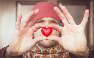 Heart shape love symbol in man hand with face on background Valentines Day romantic greeting people relationship concept winter holiday