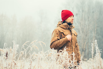 Young Man walking alone outdoor with foggy scandinavian forest nature on background Travel...
