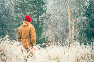 Young Man walking alone outdoor with foggy scandinavian forest nature on background Travel Lifestyle and melancholy emotions concept film effects colors