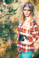 Young Woman walking with retro photo camera outdoor Lifestyle Travel forest on background