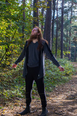 Portrait of man with a long beard and a long hair in the forest