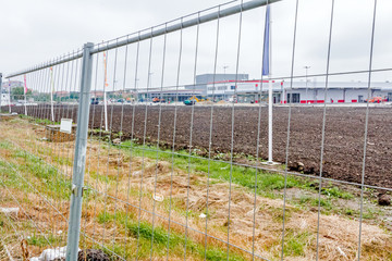 Fototapeta premium View on the construction site through a fence wire.