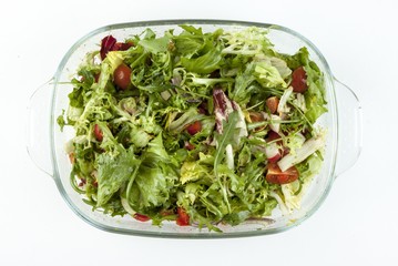Vegetable salad in a glass dish on a white background