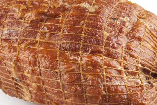 Smoked boneless pork ham hock wrapped in netting isolated on white 