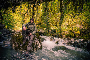 Young Man bearded relaxing hiking outdoor with river and forest wild on background Lifestyle Travel survival concept