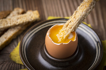 Crispy toast and boiled egg on wooden background