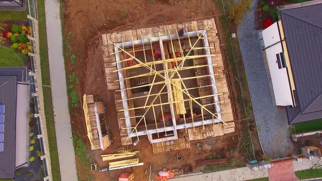Construction site of new family house. Camera flight over area for pleasant living in suburban district. Construction industry from above.