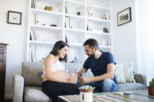 Young parents resting on sofa.