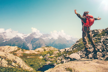 Happy Man with red backpack jumping hands raised mountains landscape on background Lifestyle Travel active summer vacations outdoor.