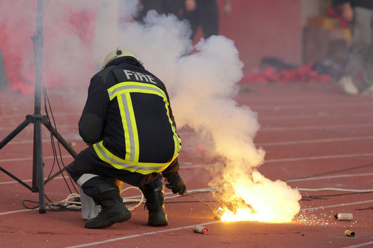 Firefighter putting down football fans' torches fire