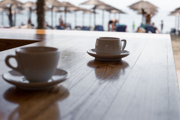 two cups of coffee  on table over sea landscape with sunlight. Beauty nature background