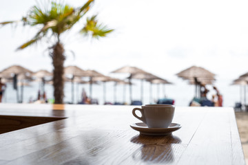 Cup with .coffee on table over sea landscape with sunlight. Beauty nature background