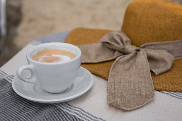 Summer coffee break , female straw hat and cup of coffee
