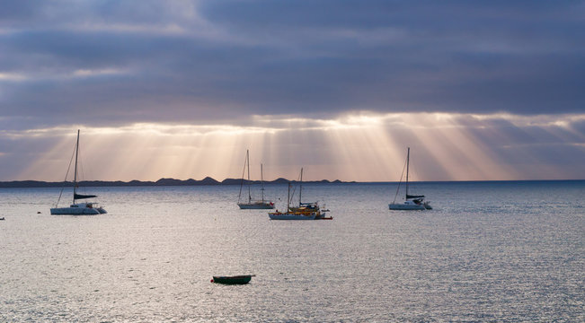 Fuerteventura, Isole Canarie: i raggi del sole all'alba e le barche a vela nel porto di Corralejo, il 5 Settembre 2016