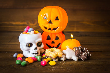Halloween set. Candy, cookies and pumpkin. On a wooden background.