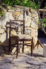 The old chair in front of old wall with flower.