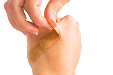 Pluck medical plasters by hand. On white, isolated background.
