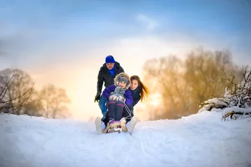Familie fährt mit dem Schlitten in den Wald © Tortuga