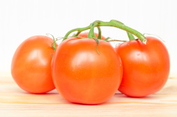 Close-up of fresh, ripe tomatoes on wood background.