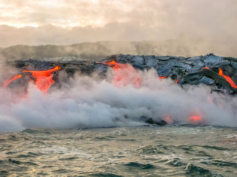 Scenic view from boat of Kilauea Volcano in Hawaii Volcanoes National Park, while erupting lava into Pacific Ocean, Big Island, Hawaii, United States.