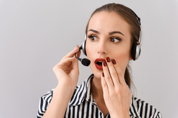 Shocked young woman working with headset