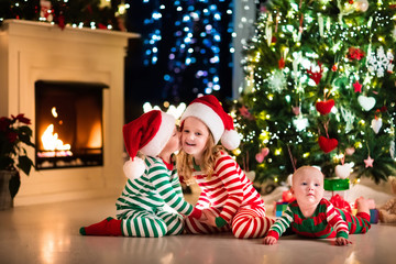Kids in pajamas under Christmas tree