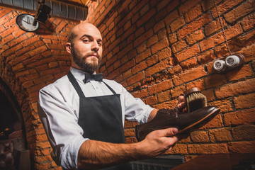 bald man shoe shining a boot