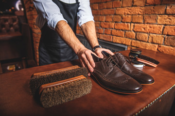 shoemaker holding a pair of brand new shoes