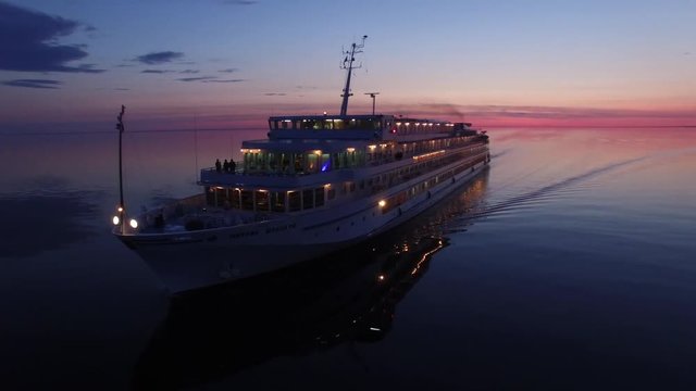 Unique aerial flight around cruise ship. Beautiful sunset. No wind. Reflection in water. 4k footage.  